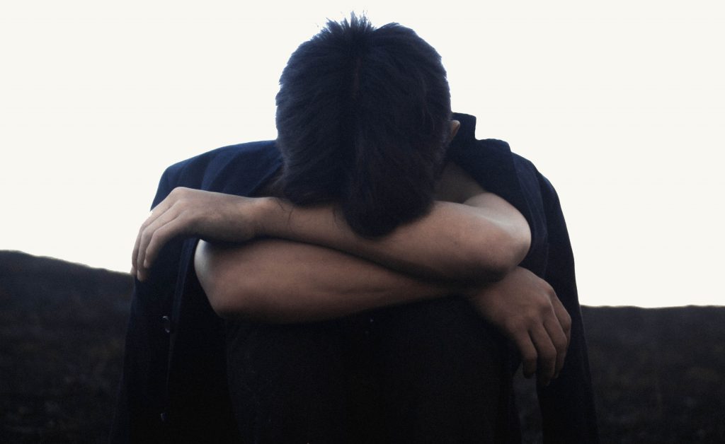 anxiety and depression image of a man with his head down in his arms